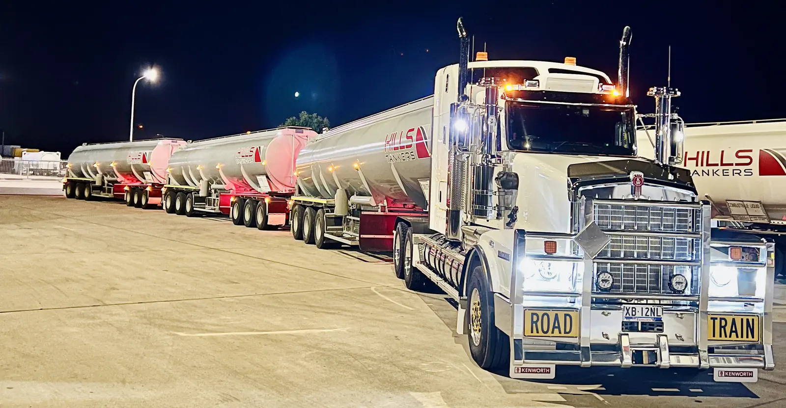 Hills Tankers Kenworth prime mover with tanker trailers at night in the depot yard