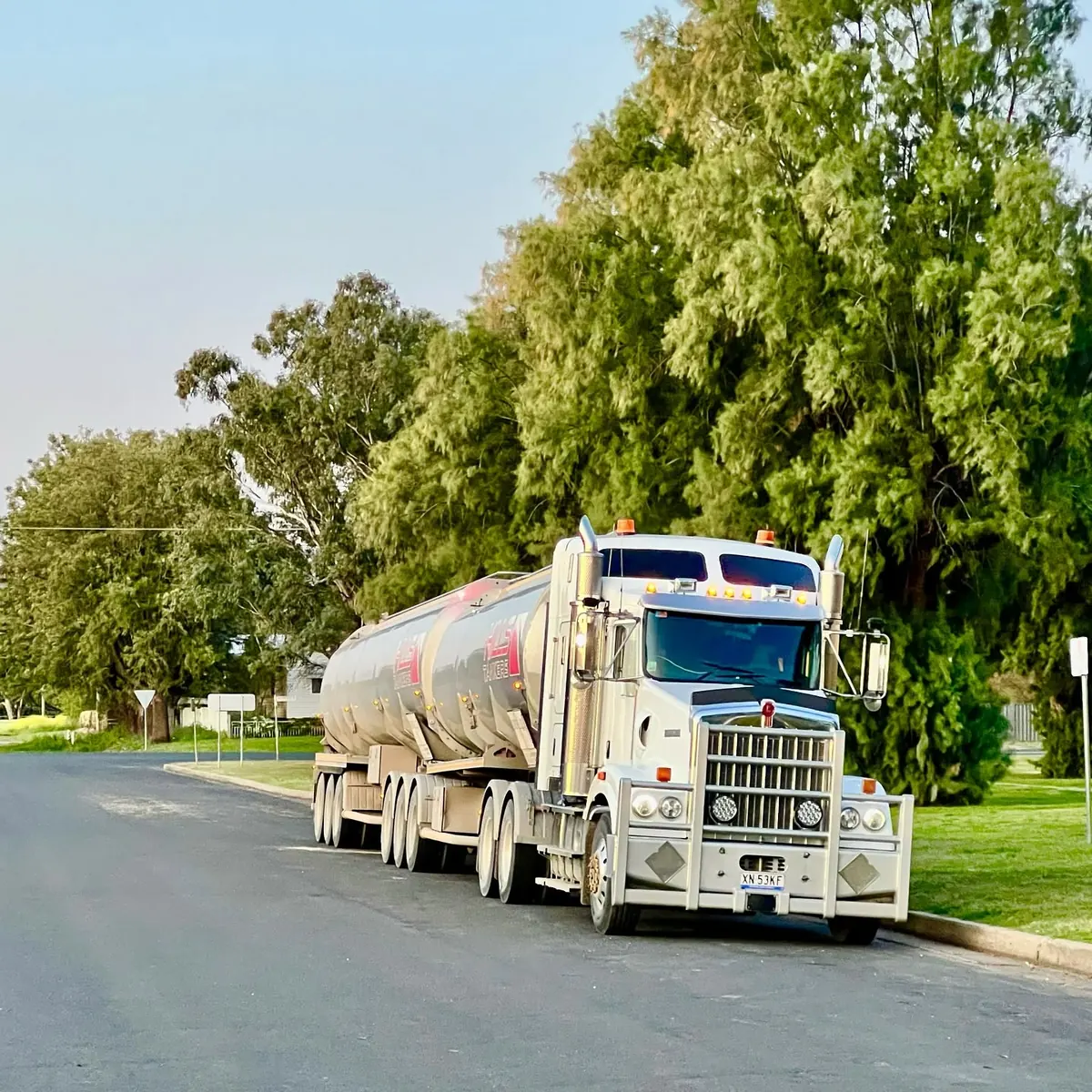 Hills Tankers Kenworth road train parked on a quiet tree-lined street in Gunnedah