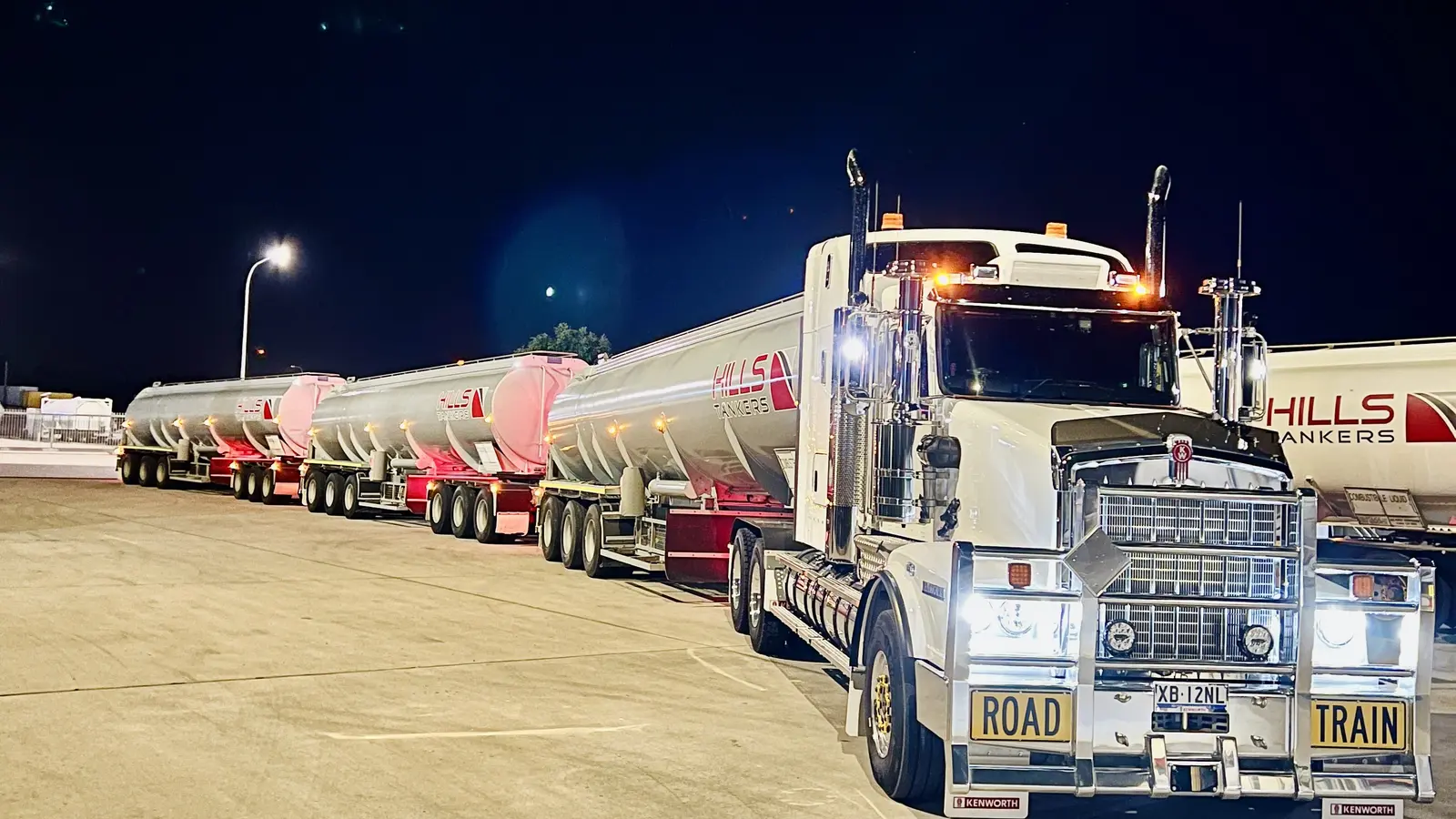 Hills Tankers Kenworth prime mover with tanker trailers at night in the depot yard